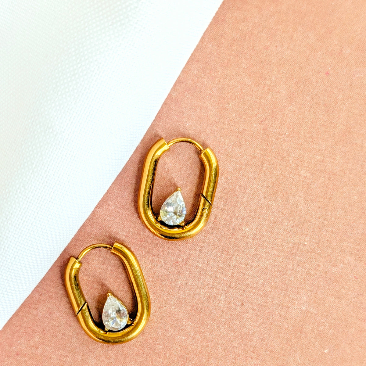 Oval huggie hoop earrings with a cubic zirconia stone