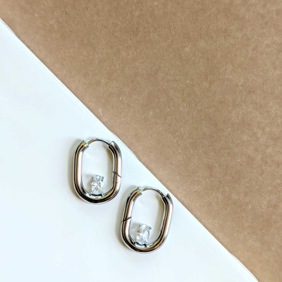 Gold and silver oval huggie hoops with cubic zirconia