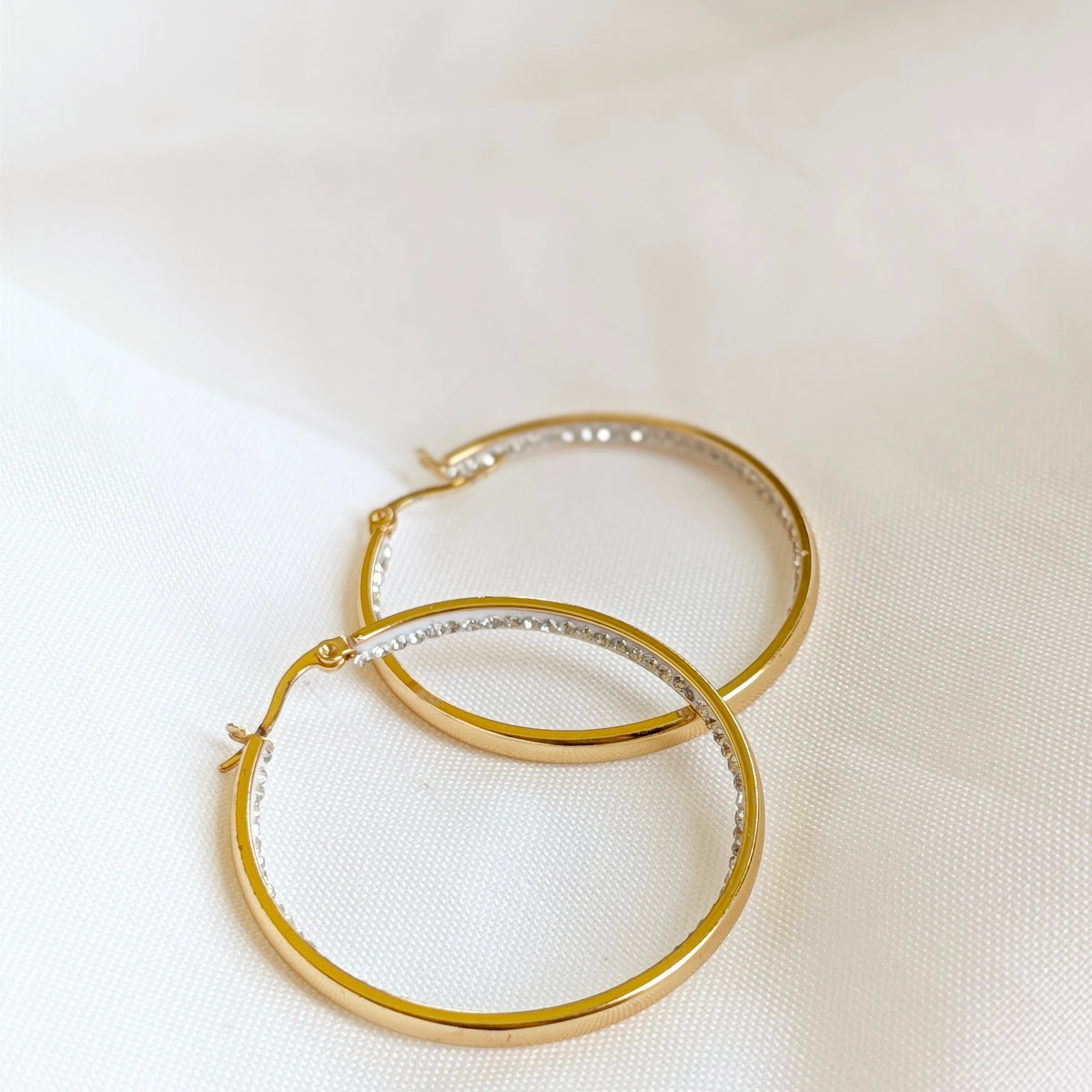 Gold stainless steel hoop earrings with crystal rhinestones on the inside
